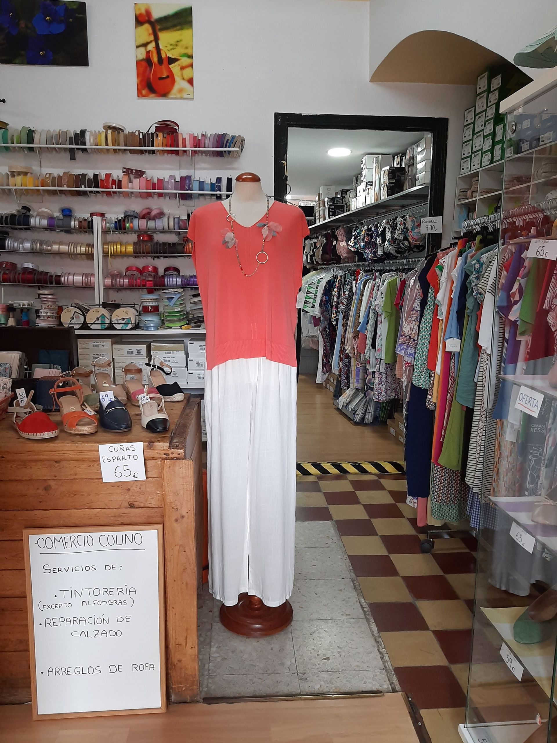 Un maniquí con un top rojo y una falda blanca en una tienda.