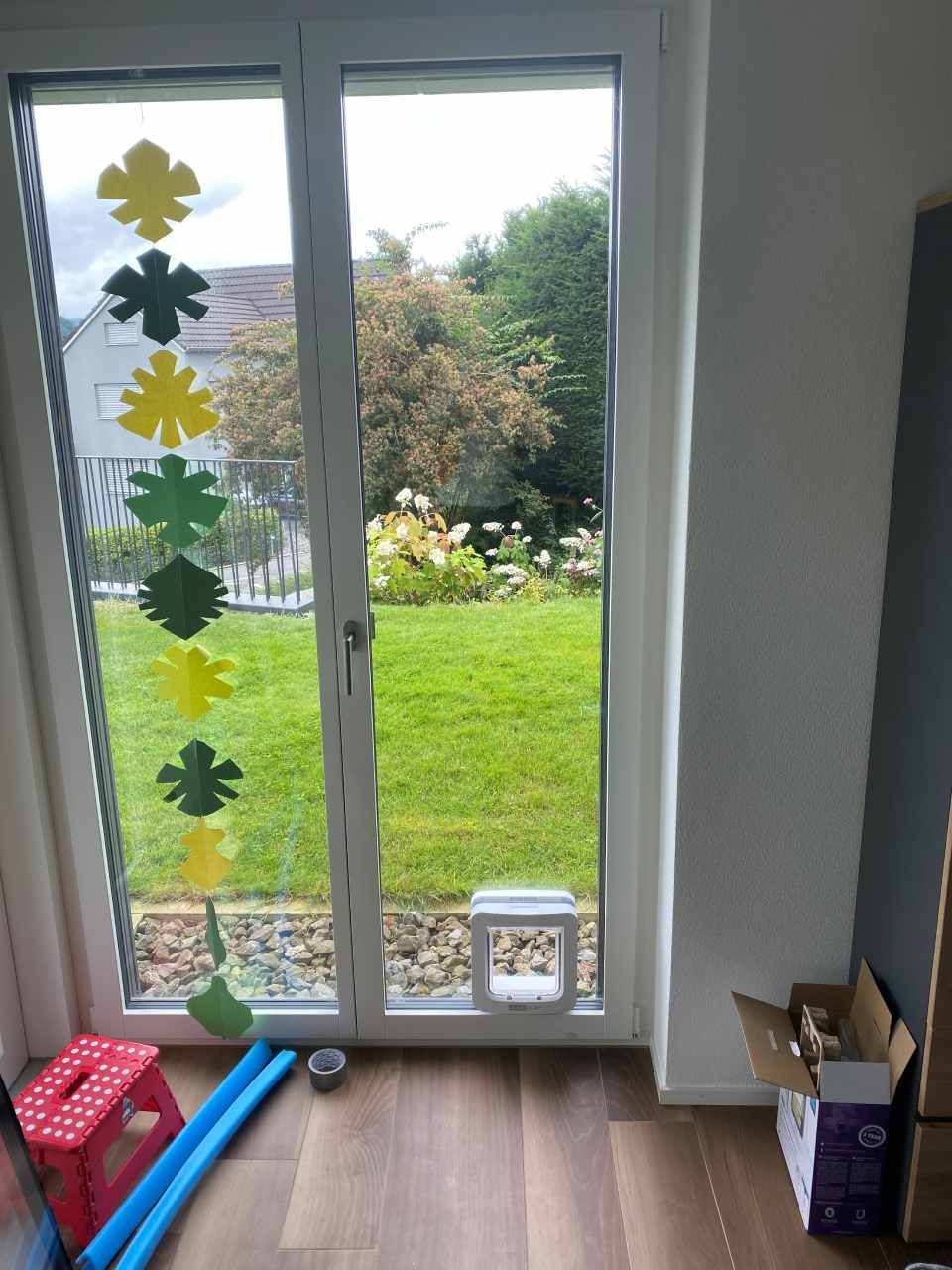 Une pièce avec une porte coulissante en verre donnant sur une cour