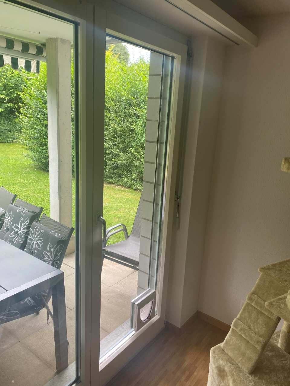 Un salon avec une porte coulissante en verre donnant sur un patio.