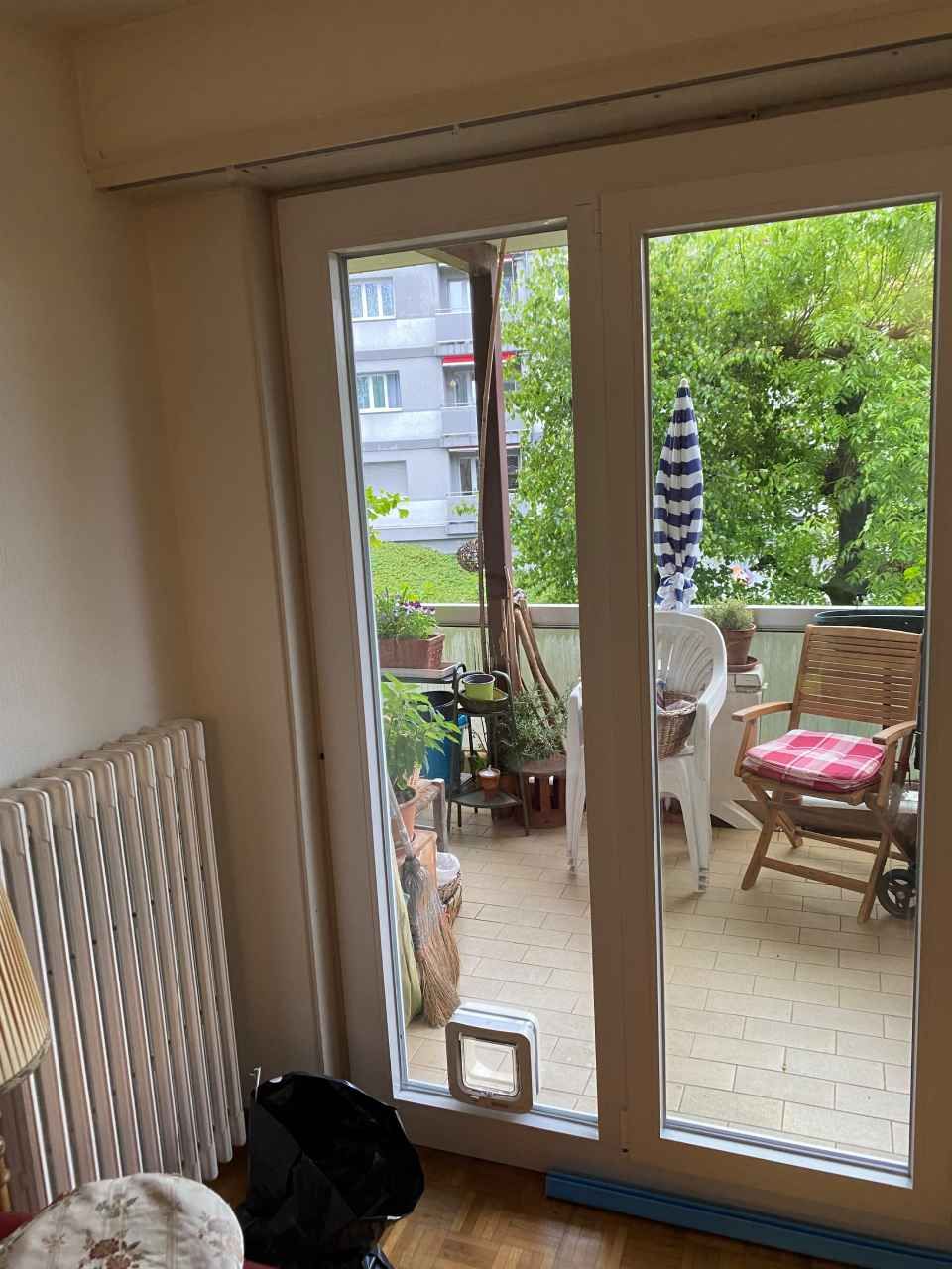 Une pièce avec une porte coulissante en verre donnant sur un balcon.