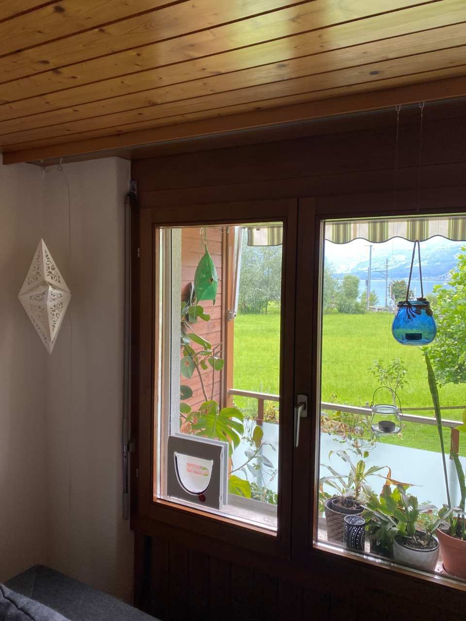 Un salon avec un canapé et une fenêtre avec vue sur un champ.