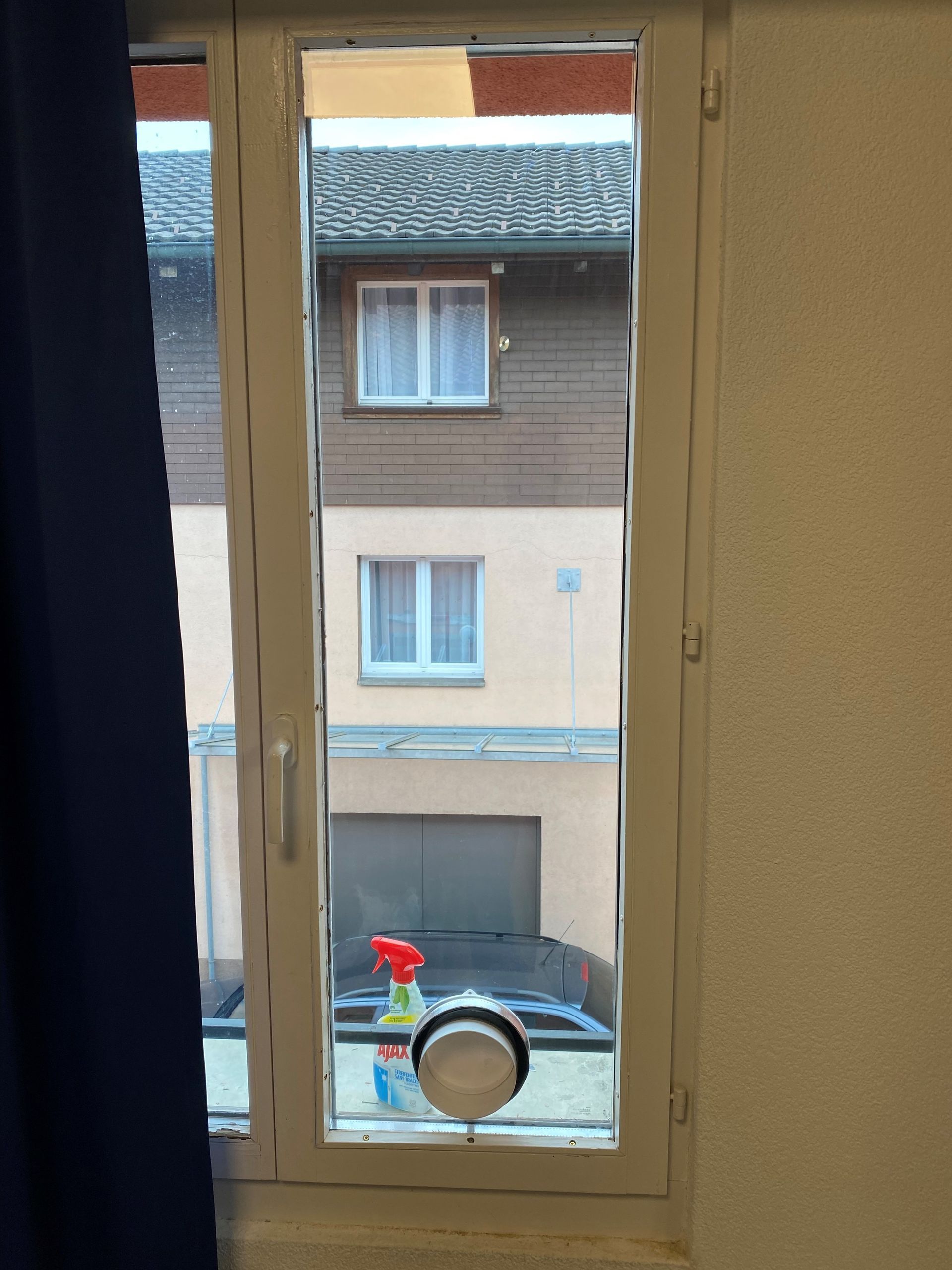 Une fenêtre avec un vaporisateur sur le rebord de la fenêtre