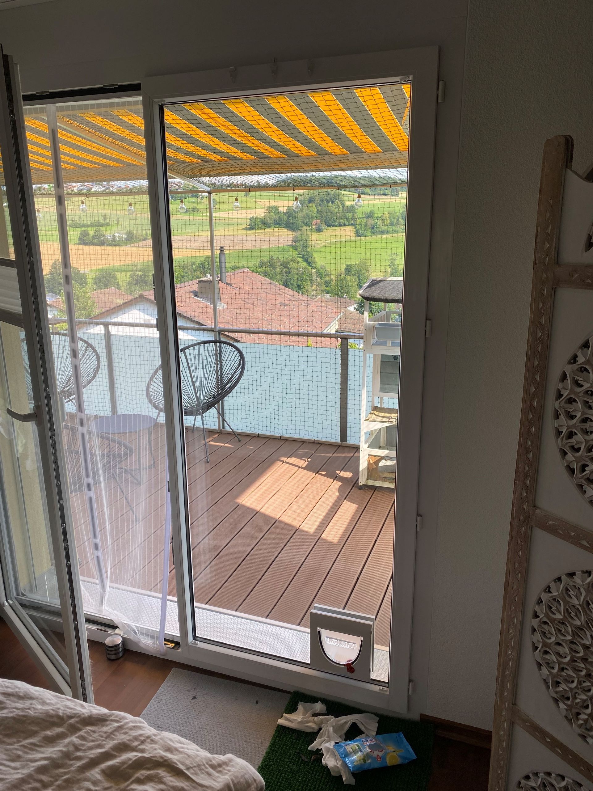 Une chambre avec une porte coulissante en verre donnant sur un balcon.