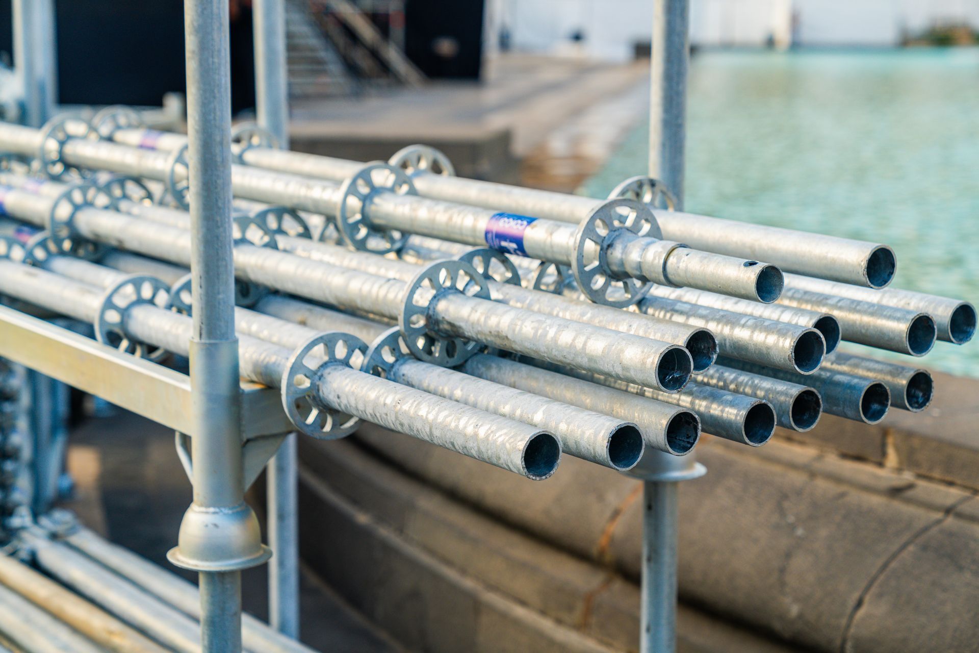 Gestapelte silberne Metallrohre auf einem Gestell in einer Industrieumgebung