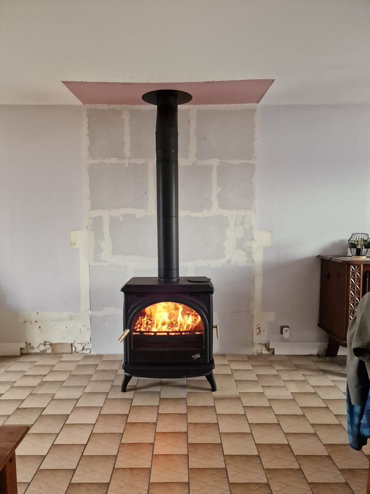 Poêle avec tubage noir en fonctionnement dans un appartement