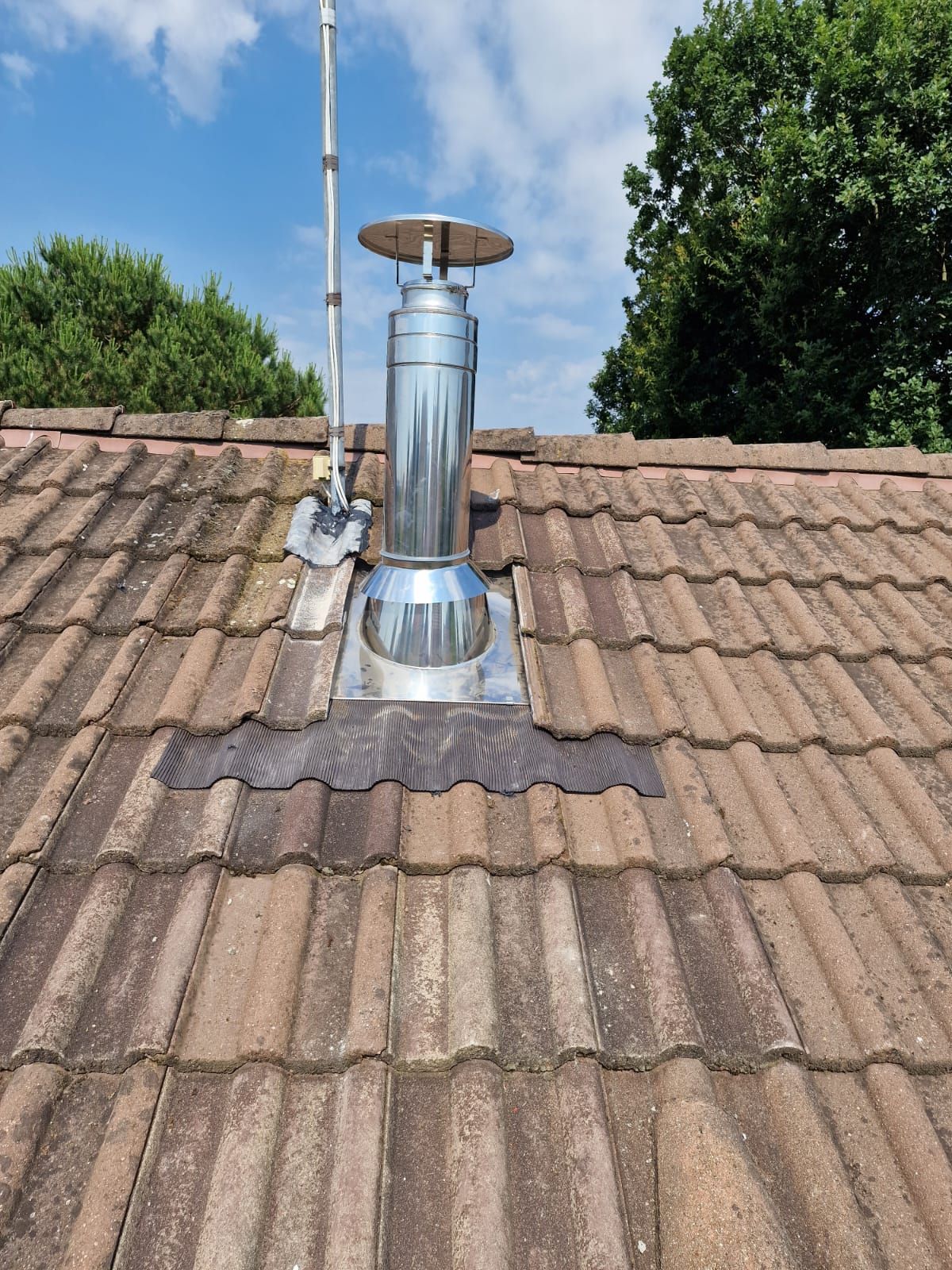 Bouche d'évacuation de cheminée sur un toit en tuiles