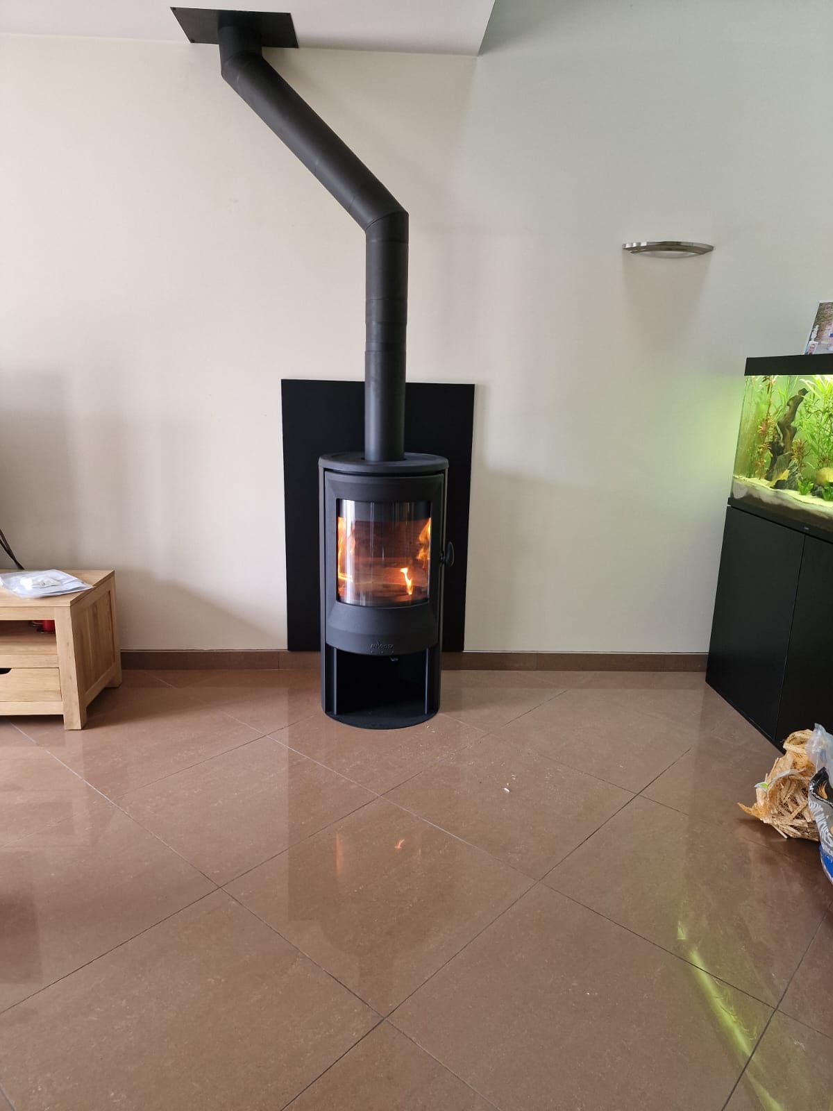 Poêle dans une pièce de vie avec grand tubage noir