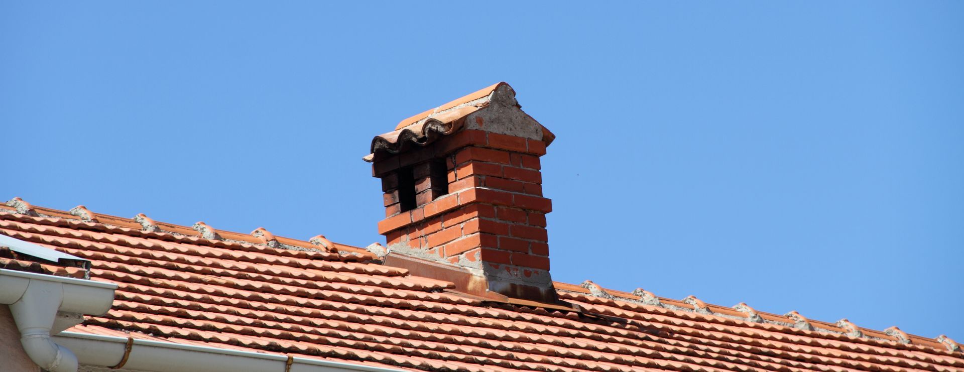 Cheminée ancienne sur un toit en tuiles