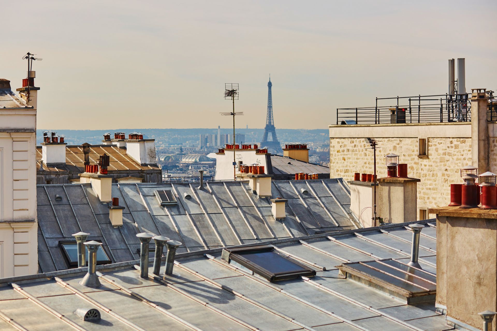 Toits de Paris avec de nombreuses cheminées et vue sur la Tour Eiffel