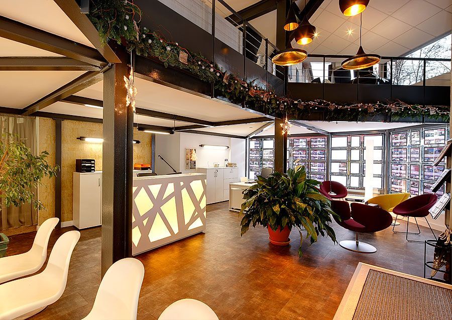 Espace d'accueil moderne avec mezzanine et éclairage décoratif.