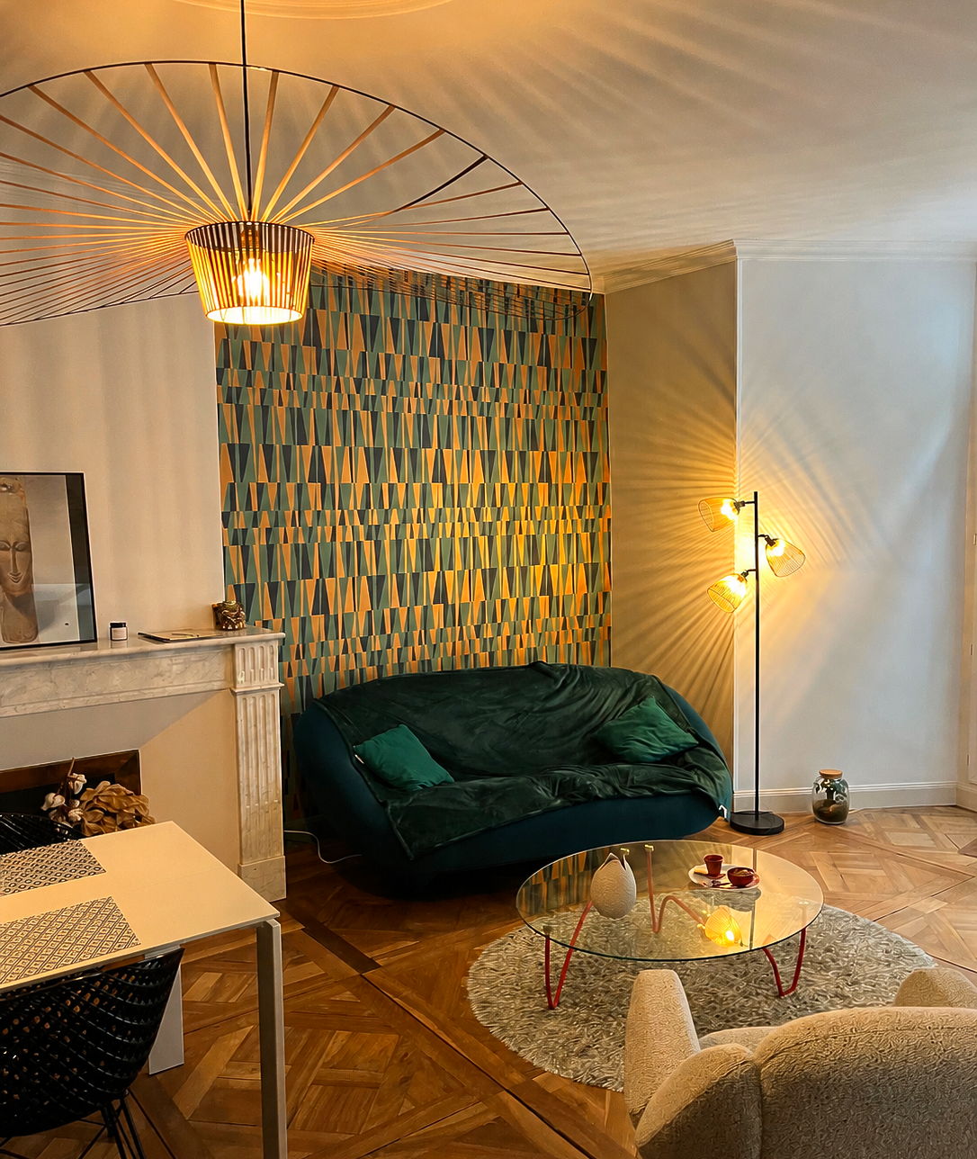 Coin repas avec une table blanche, des chaises noires et une cheminée dans un appartement moderne.