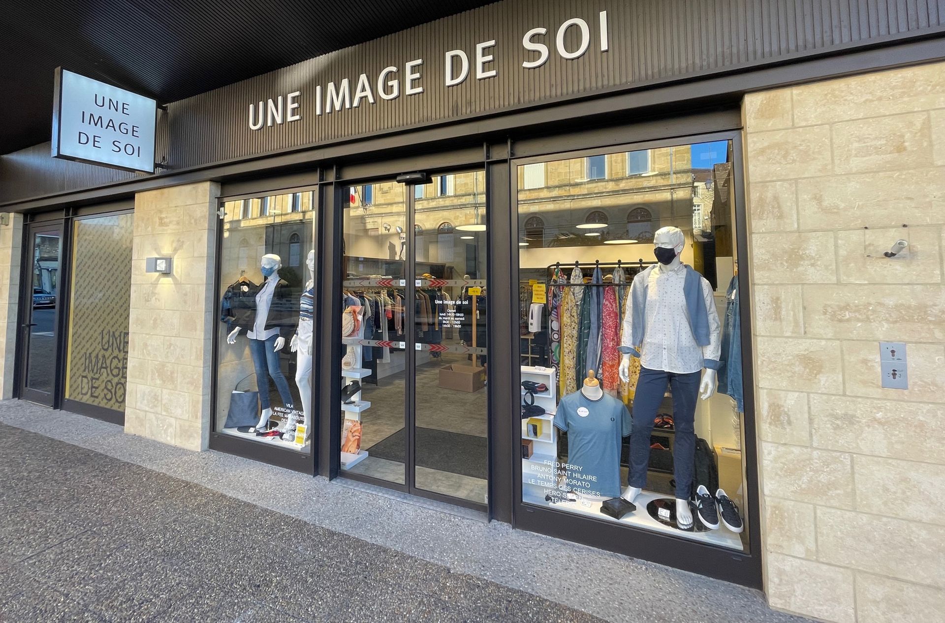 Magasin de vêtements Une Image De Soi  avec des mannequins présentant des vêtements en vitrine.
