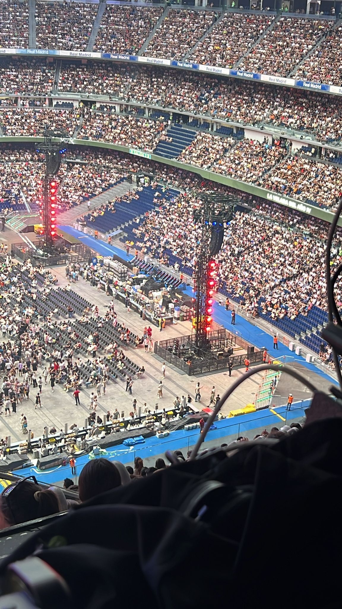 Una gran multitud de personas está sentada en un estadio viendo un concierto.