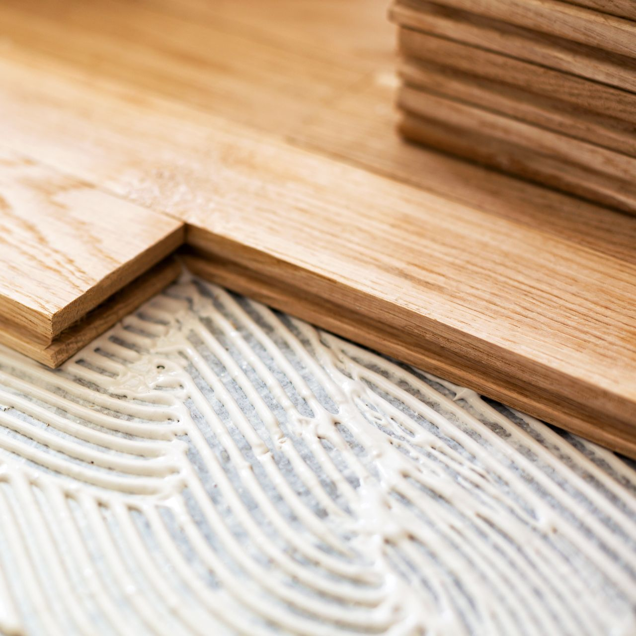 Planches de bois installées avec de la colle sur une surface grise, gros plan.