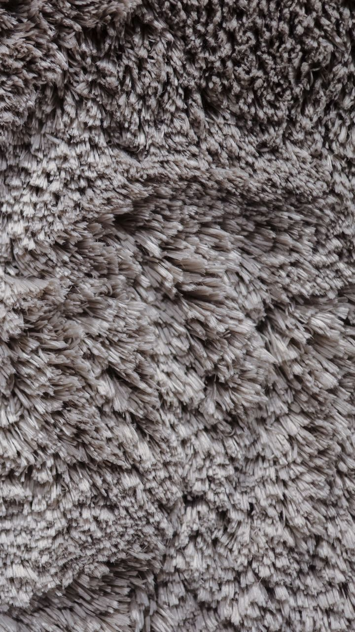 Gros plan d'un tissu gris et moelleux avec une texture hirsute.