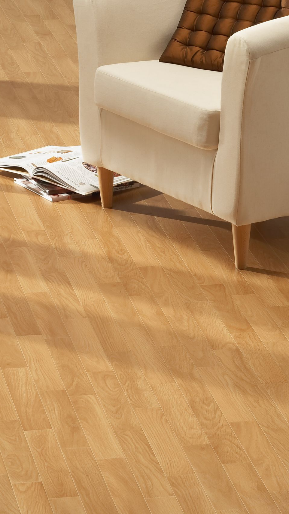 Fauteuil beige avec coussin marron et parquet imitation bois. Journaux au sol.