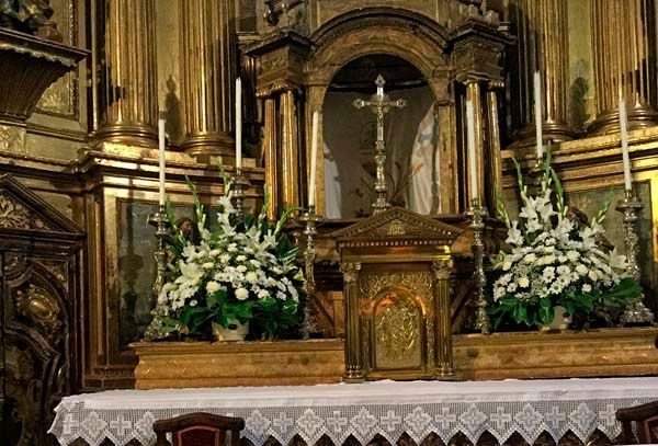 Un altar en una iglesia decorado con flores y velas.