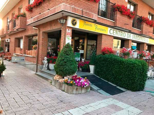 Un edificio de ladrillo con un cartel amarillo que dice centro de jardineria