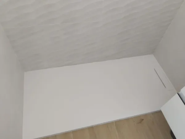 Un baño con cabina de ducha y suelo de madera.