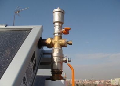 Un primer plano de una válvula en un techo con un cielo azul de fondo.