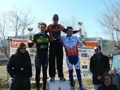 Un grupo de hombres están de pie en un podio sosteniendo trofeos frente a un cartel que dice abierto.