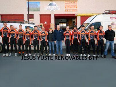 Un grupo de personas posa para una foto frente a un edificio que dice Jesús Yuste Renovables BTT.