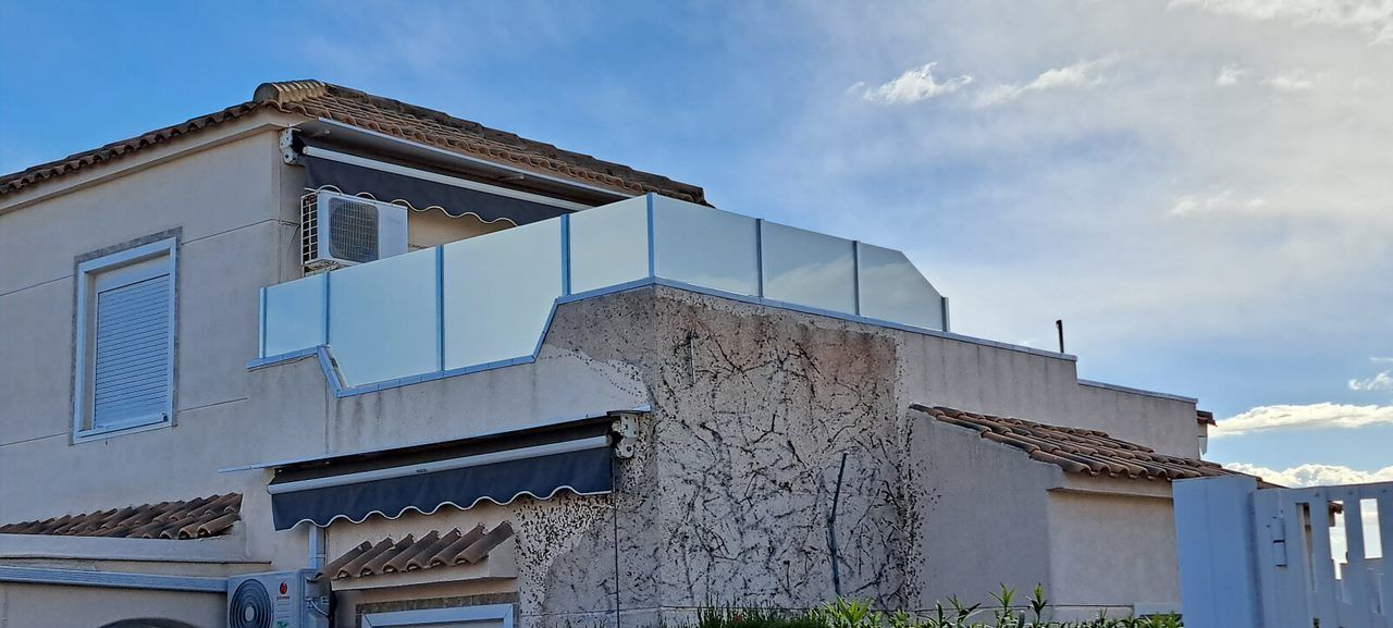 Una gran casa blanca con un balcón y un cielo azul al fondo.