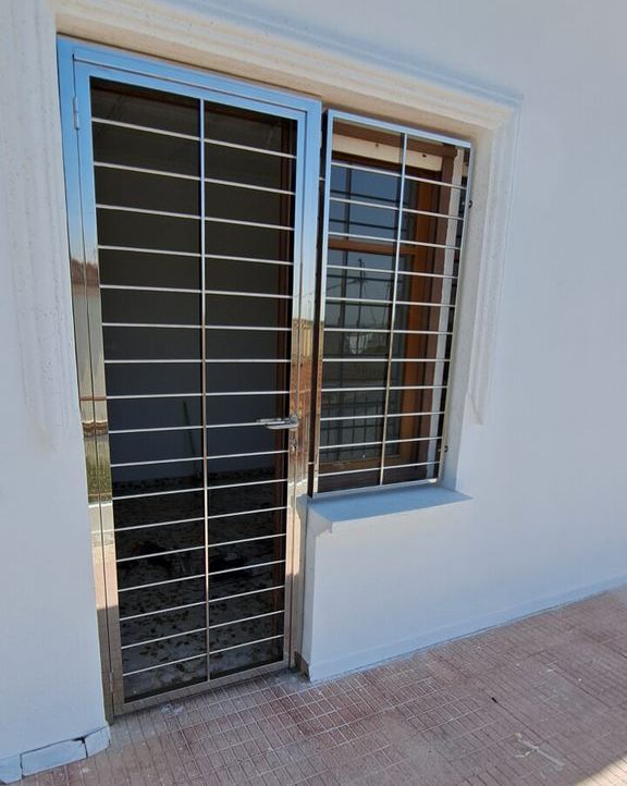 Una puerta de acero inoxidable con una ventana detrás.