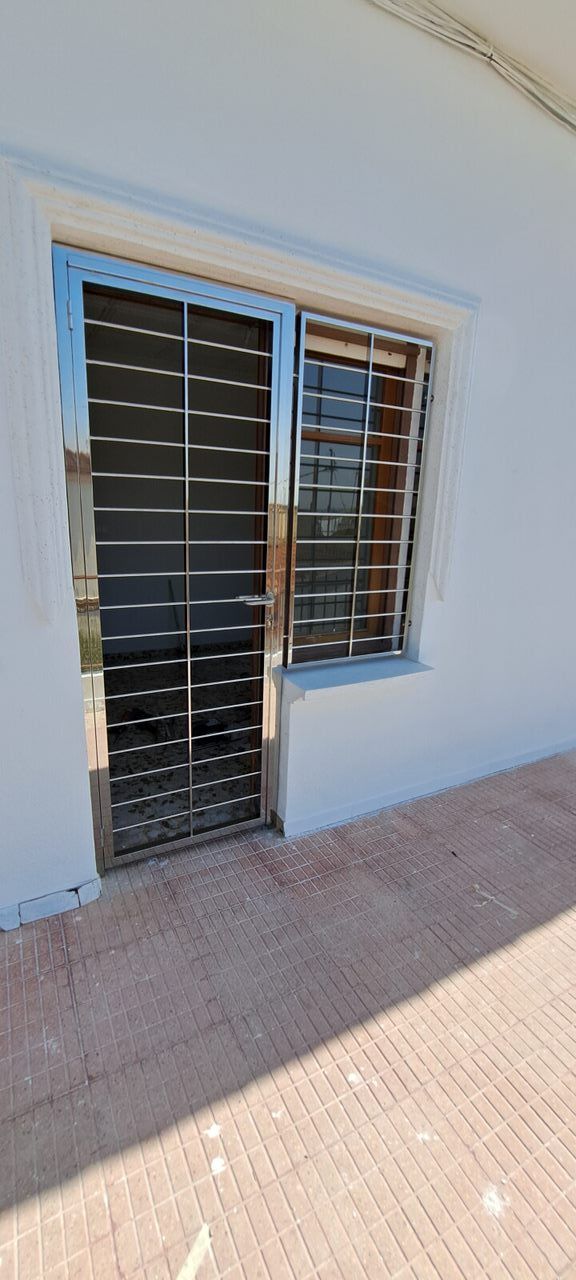 Un edificio blanco con ventanas y puertas de acero inoxidable.