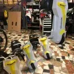 Un robot está sentado en un suelo de baldosas en una habitación.