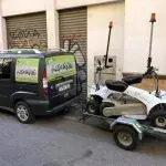 Una camioneta remolca una cortadora de césped en un remolque.