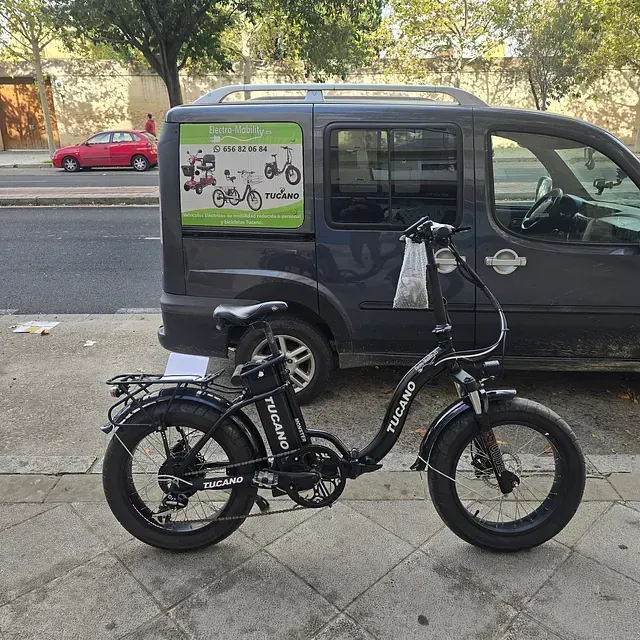 Una bicicleta tucano está estacionada frente a una camioneta