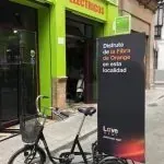 Una bicicleta está estacionada frente a un edificio verde.