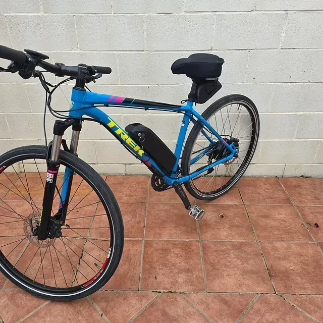 Una bicicleta Trek azul está estacionada en un piso de baldosas.