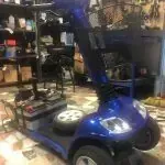 Un scooter de movilidad azul está estacionado en un garaje.