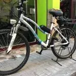 Una bicicleta está estacionada en la acera frente a una tienda.