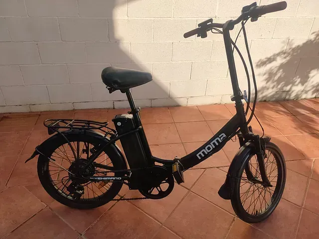 Una bicicleta mona negra está estacionada en un piso de baldosas