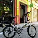 Una bicicleta está estacionada al costado de la carretera frente a una tienda.