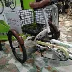 Un triciclo con una cesta en la parte trasera está aparcado en el suelo.