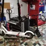 Un montón de scooters están sentados sobre una mesa en una habitación.