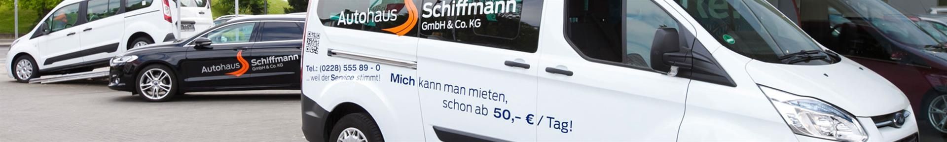 Eine Reihe weißer Lieferwagen parkt am Straßenrand.