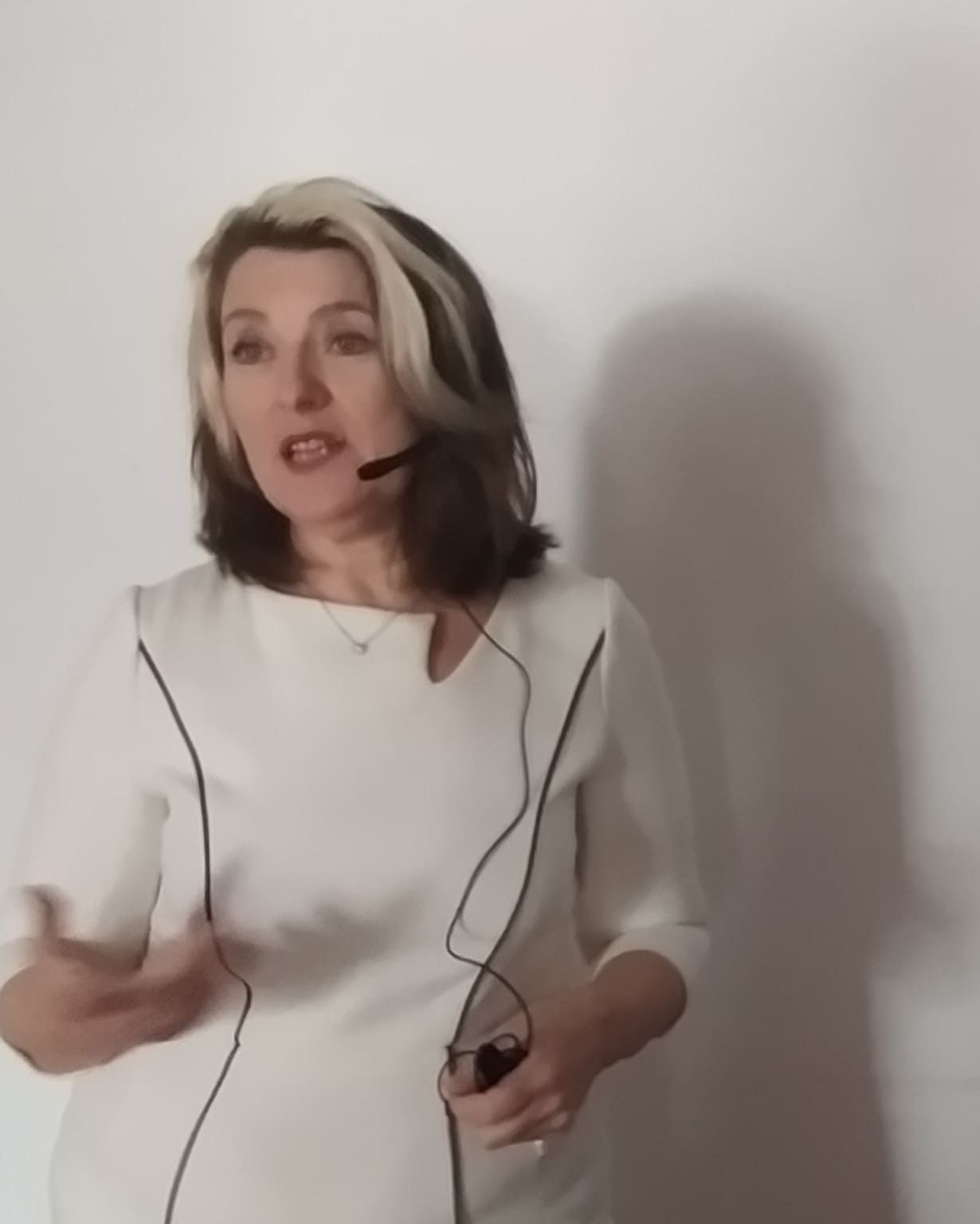 Una mujer con un vestido blanco lleva unos auriculares.