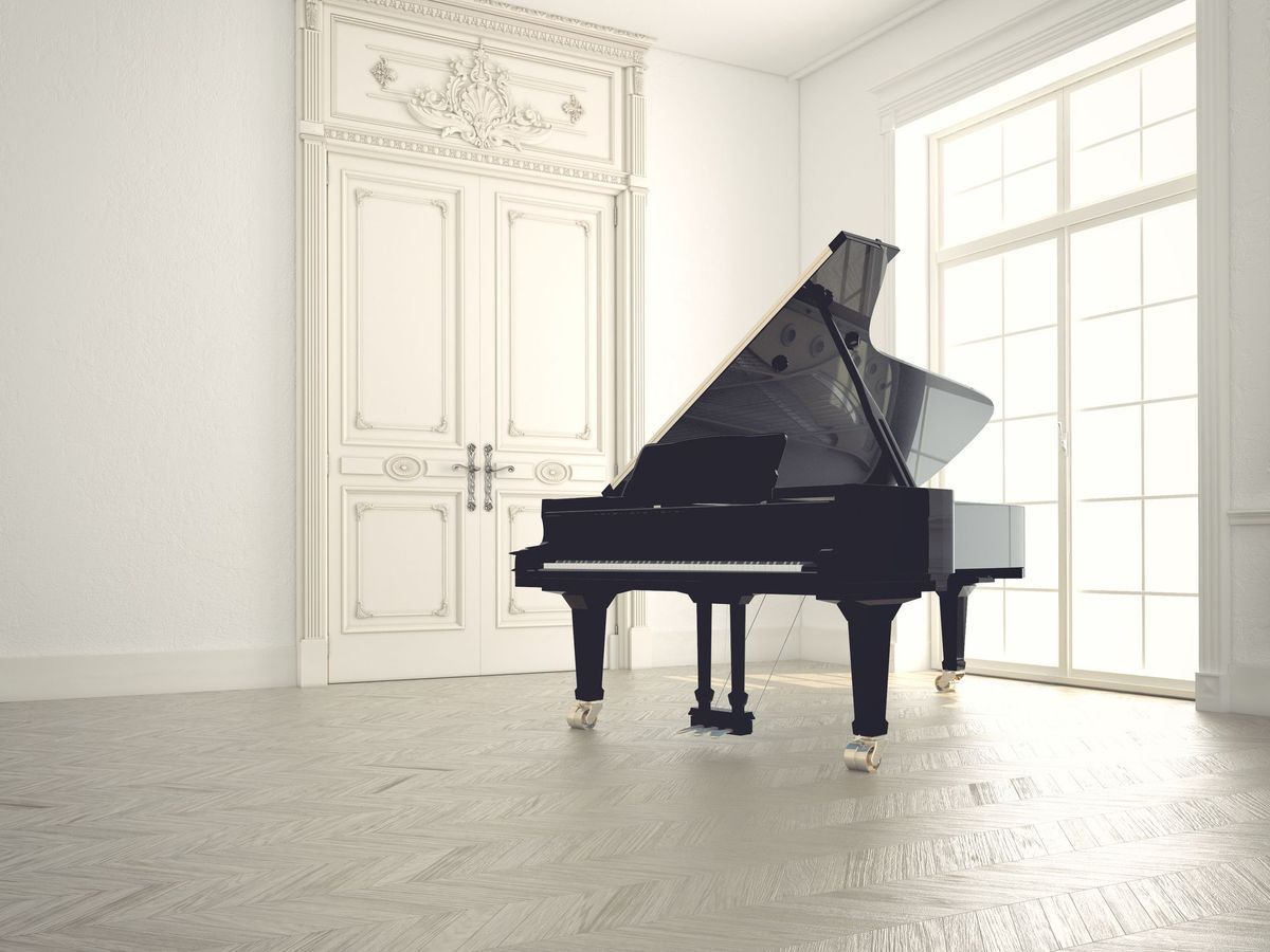 Un piano à queue noir dans une pièce d'un blanc éclatant, avec des portes ornées et de hautes fenêtres.