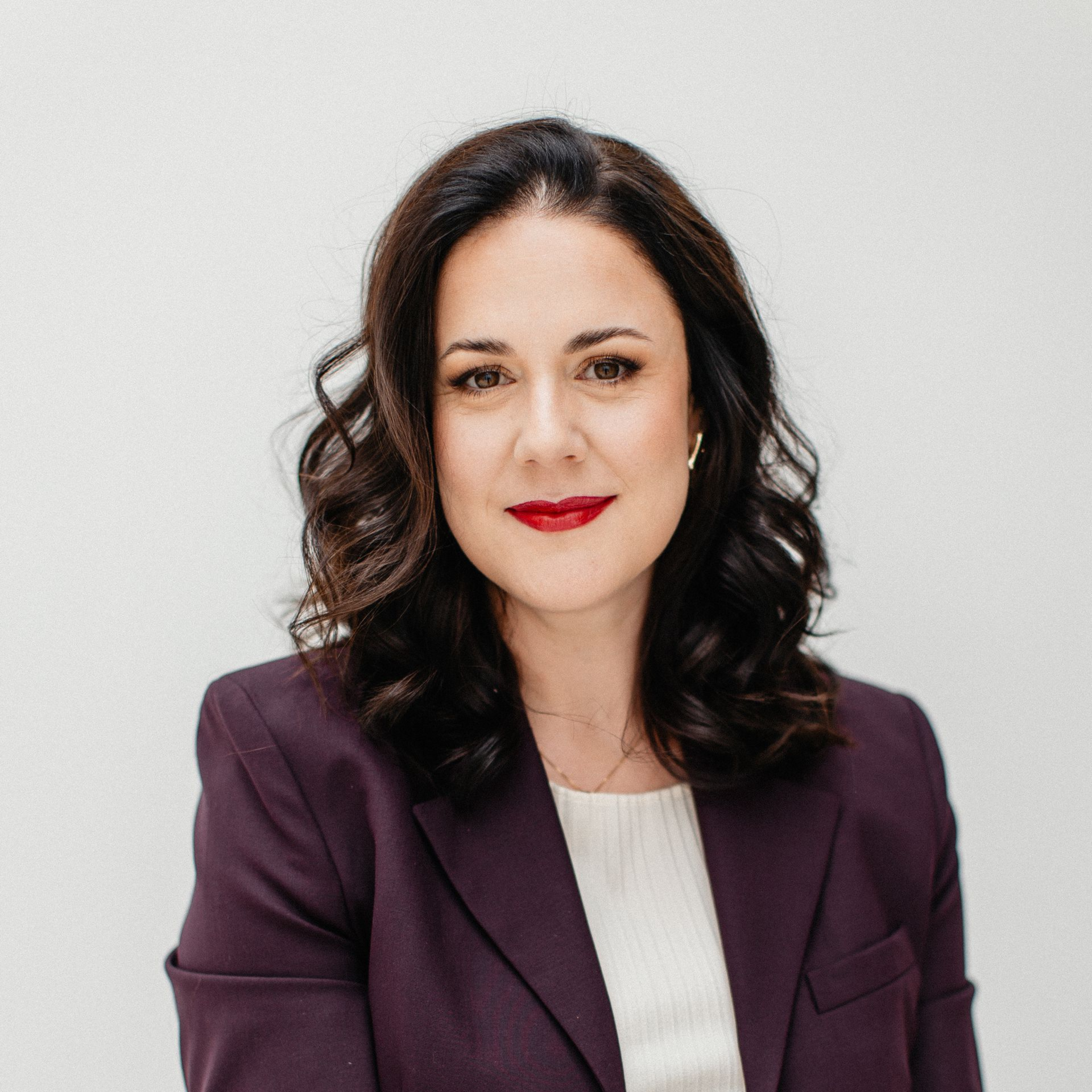 Eine Frau im Anzug schaut in die Kamera