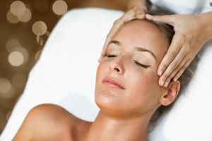 Eine Frau bekommt in einem Spa eine Kopfmassage.