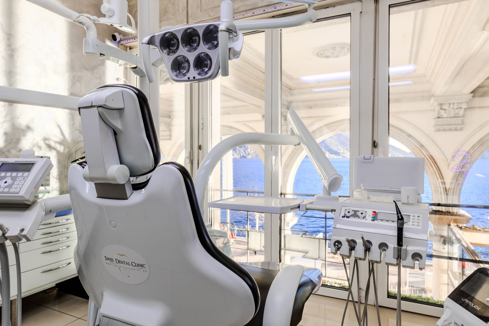 Poltrona odontoiatrica in una stanza luminosa con attrezzatura e finestra con vista.