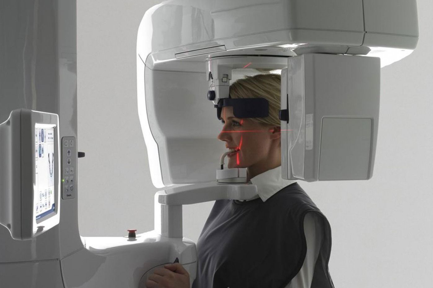 Un dentista indica la scansione 3D dei denti su un monitor touchscreen in uno studio dentistico.