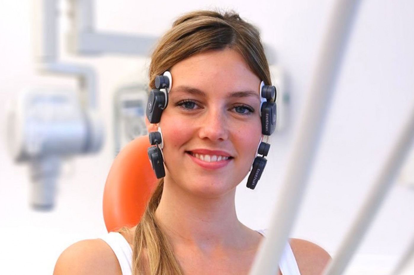 Persona sorridente con tabella comparativa delle tonalità dei denti.