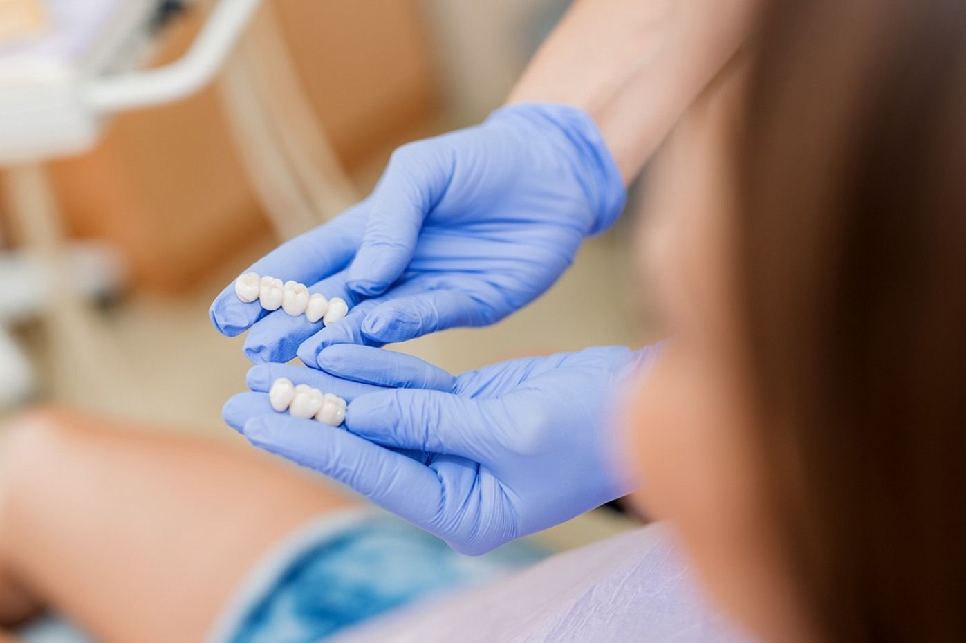 Uno studio dentistico con una poltrona color verde acqua, strumenti e attrezzature odontoiatriche.