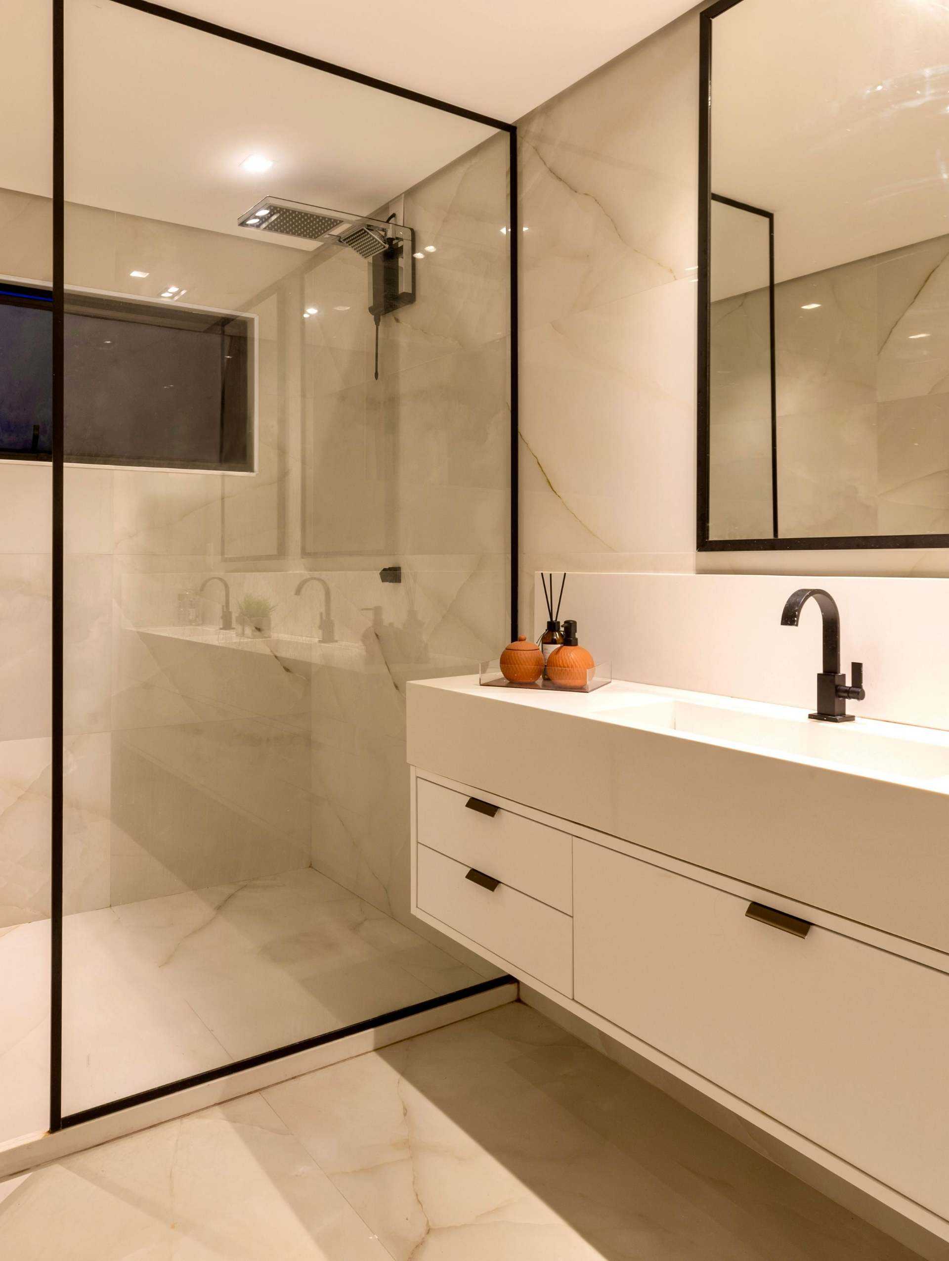 Salle de bains en construction avec douche, fenêtre et cloisons sèches apparentes.